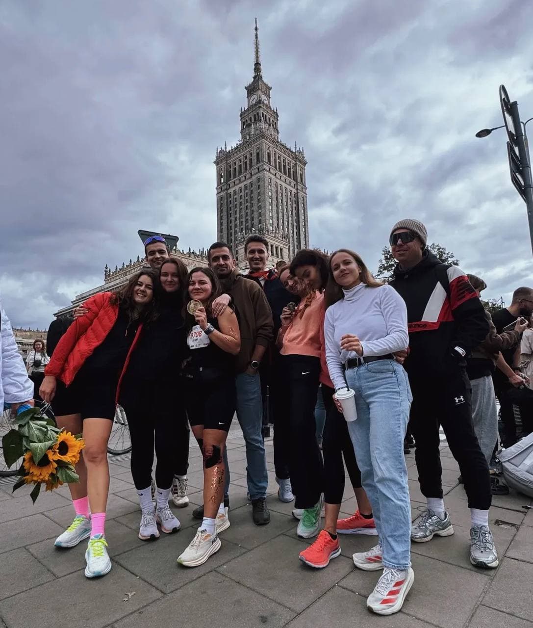 URC crew celebrating after a Warsaw race, Palace of Culture in the background